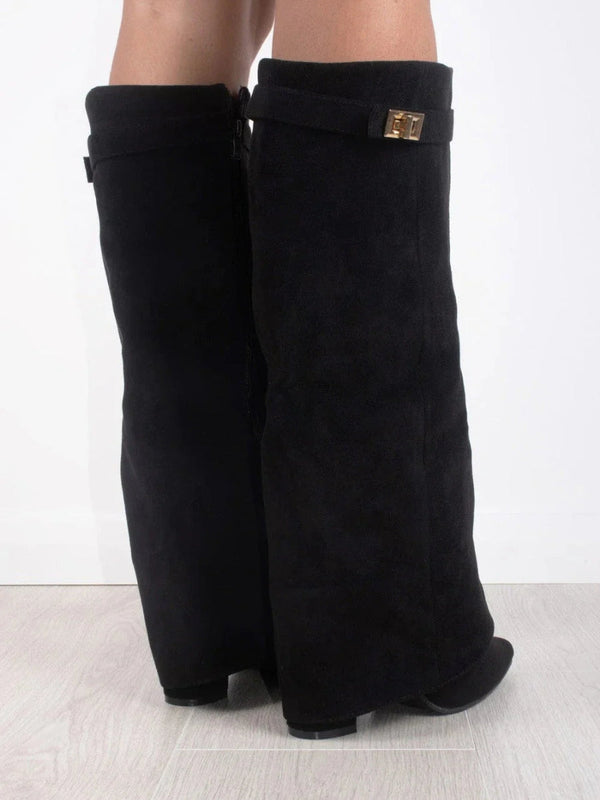 Stivali neri alti in pelle scamosciata con fibbia dorata, design elegante, su pavimento chiaro. Scarpe moda donna, calzature autunno inverno.