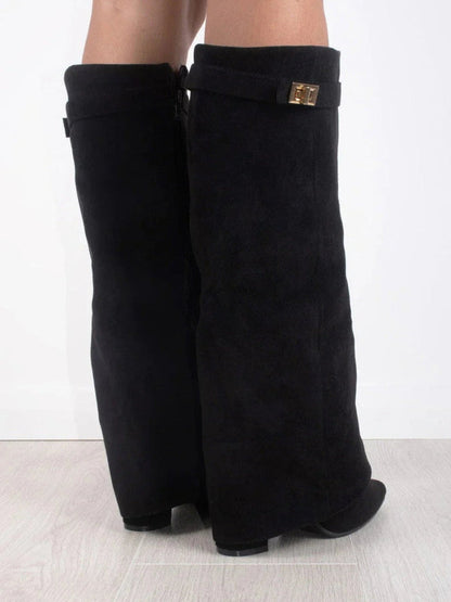 Stivali neri alti in pelle scamosciata con fibbia dorata, design elegante, su pavimento chiaro. Scarpe moda donna, calzature autunno inverno.