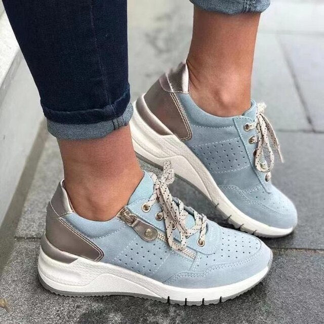 Scarpe da ginnastica donna azzurre con dettagli metallici, suola bianca spessa, lacci bianchi. Moda casual, calzature comode, stile urbano.