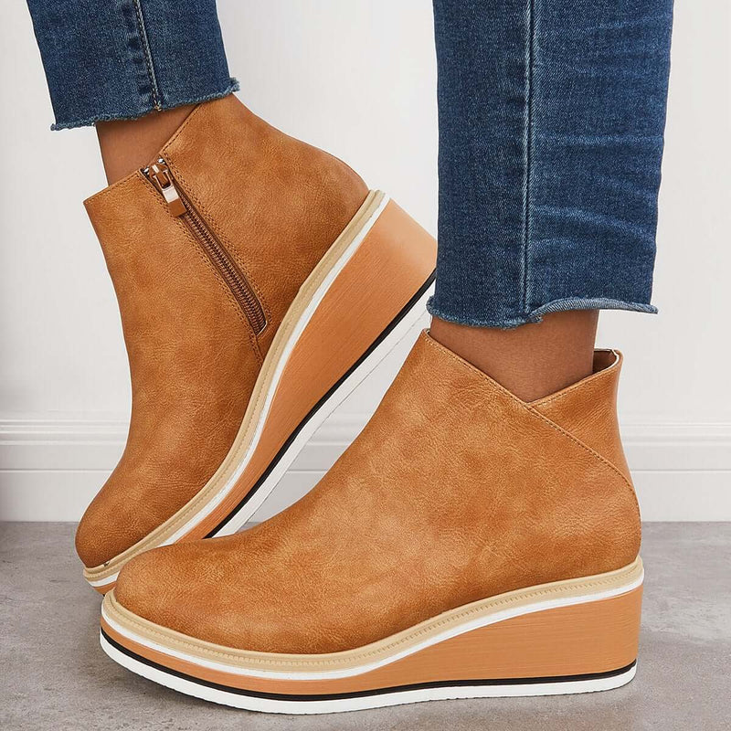 Stivaletti donna in pelle marrone con zeppa, zip laterale, abbinati a jeans. Scarpe moda autunno, calzature eleganti e comode.