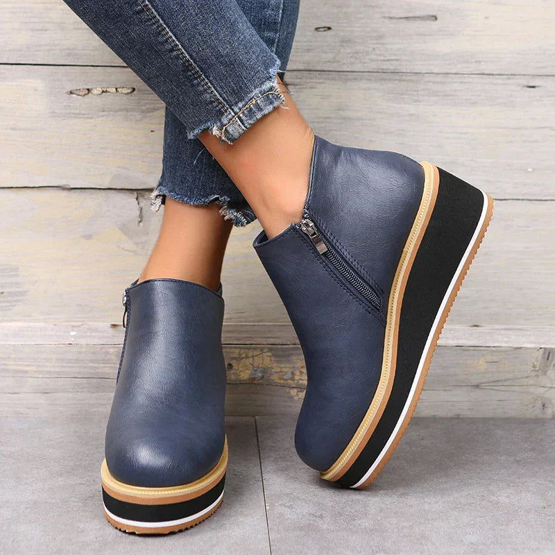 Scarpe donna blu con zeppa, cerniera laterale, suola bicolore, abbinate a jeans strappati. Calzature moda autunno, stile casual chic.