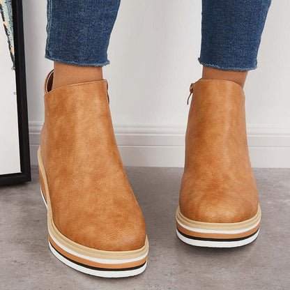 Stivaletti donna in pelle marrone chiaro, suola spessa a strati, abbinati a jeans aderenti. Scarpe moda autunno, stile casual chic.