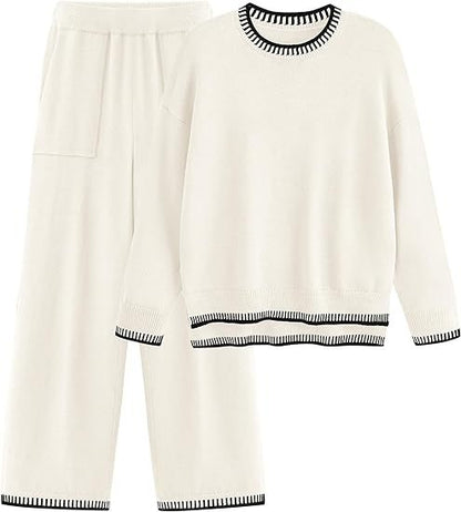 Set pigiama donna bianco, maglia e pantaloni, bordi neri a contrasto, tessuto morbido, abbigliamento notte elegante e confortevole.