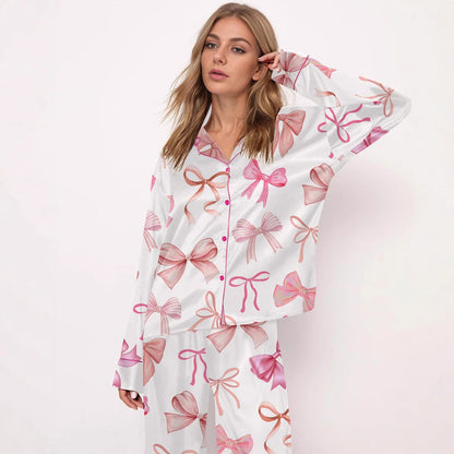 Donna in pigiama bianco con fiocchi rosa, posa su sfondo bianco. Moda notte femminile, abbigliamento comodo, stile elegante.