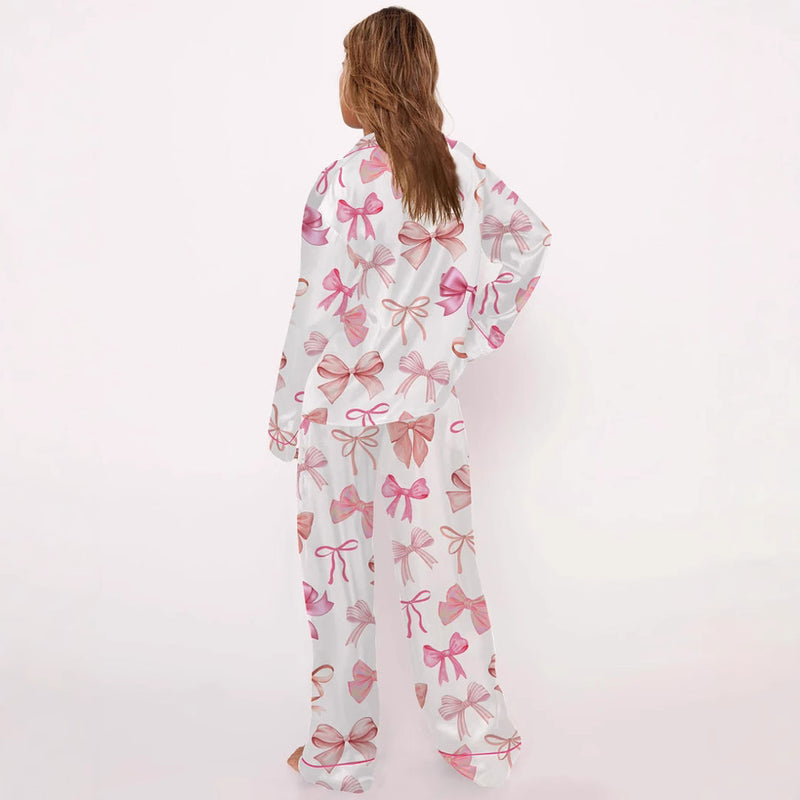 Donna in pigiama bianco con fiocchi rosa, vista posteriore. Abbigliamento notte elegante, moda femminile, comfort domestico.