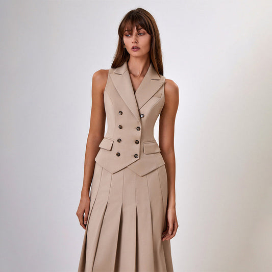 Donna in abito beige elegante senza maniche, con bottoni doppiopetto e gonna a pieghe. Moda femminile, stile sofisticato, abbigliamento formale.