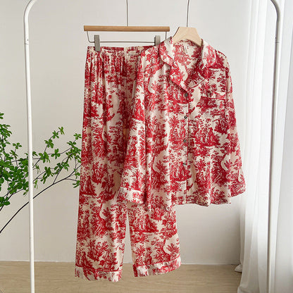 Pigiama donna in raso rosso e bianco con stampa floreale, appeso su appendiabiti in una stanza luminosa. Elegante e confortevole.