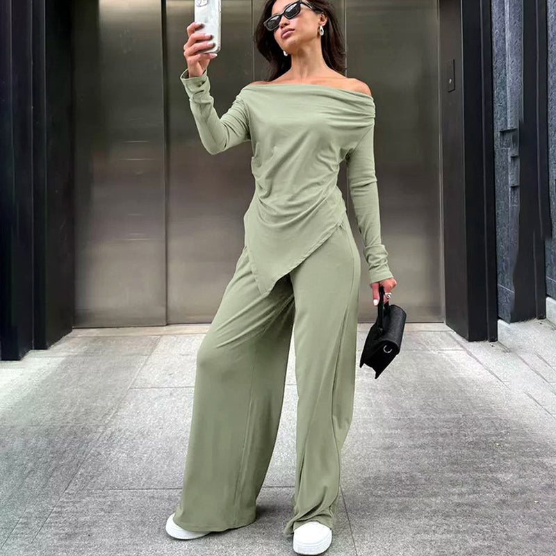 Donna con tuta verde oliva, occhiali da sole e borsa nera, scatta un selfie davanti a un ascensore. Moda casual elegante, abbigliamento femminile trendy.
