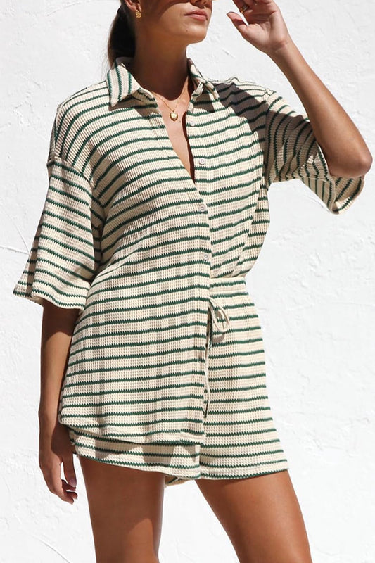 Donna in abito estivo a righe verdi e bianche, maniche corte, sfondo bianco. Moda casual, abbigliamento estivo, stile contemporaneo.
