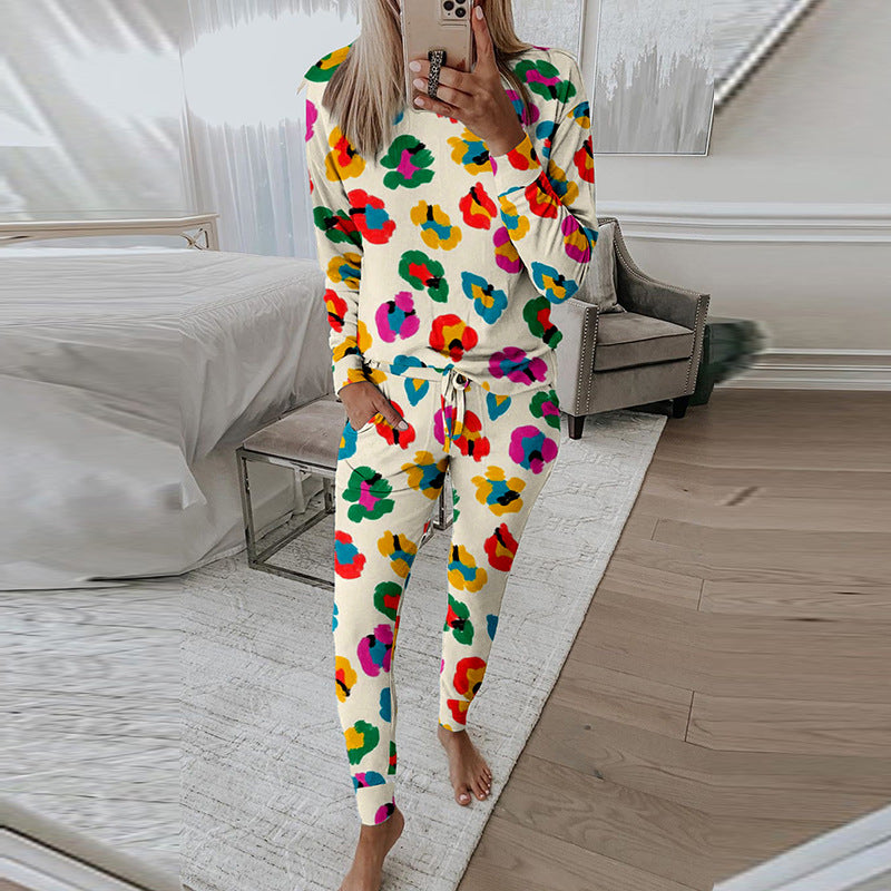 Donna in pigiama colorato a fiori, in piedi in una camera da letto moderna, scatta un selfie. Arredamento elegante, pavimento in legno.
