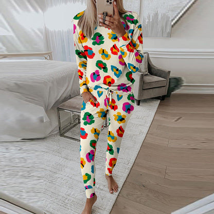 Donna in pigiama colorato a fiori, in piedi in una camera da letto moderna, scatta un selfie. Arredamento elegante, pavimento in legno.