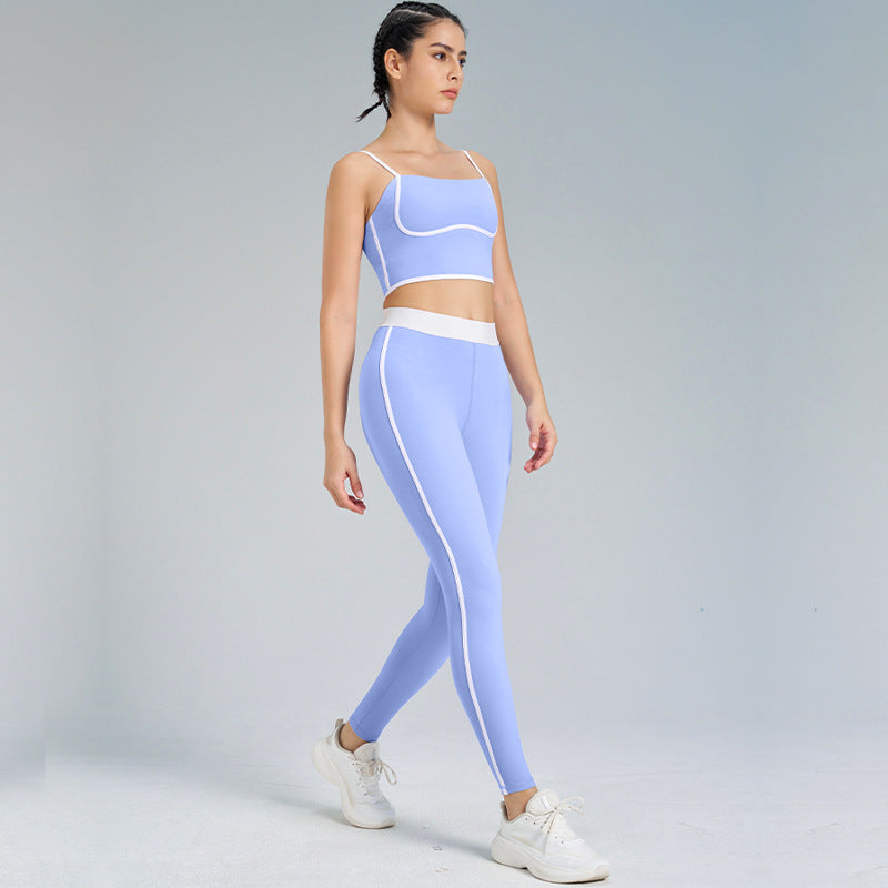 Donna in abbigliamento sportivo blu, top e leggings coordinati, cammina su sfondo neutro. Moda fitness, abbigliamento activewear donna.