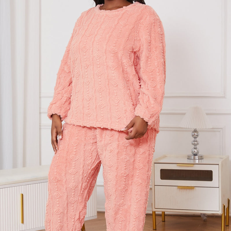 Donna in pigiama rosa soffice, tessuto a maglia, in una stanza moderna con mobili bianchi e dorati. Comfort e moda per la casa.