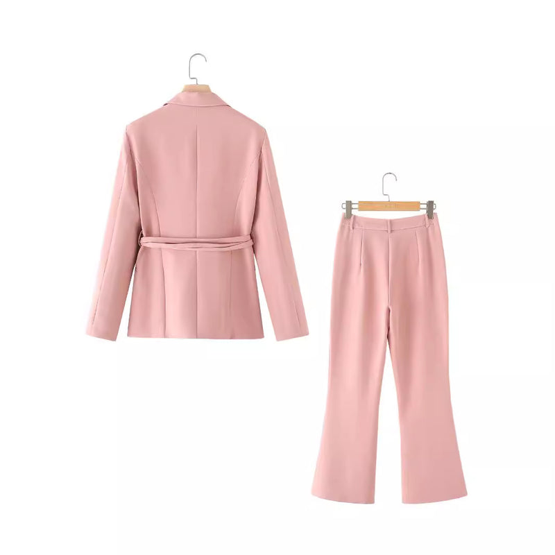 Completo donna rosa, giacca e pantaloni eleganti su appendiabiti. Moda femminile, abbigliamento formale, tendenza 2023.