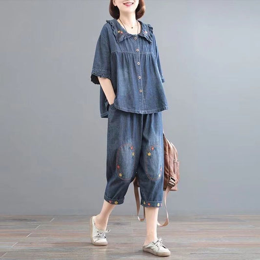 Donna in abbigliamento casual denim, camicia e pantaloni ricamati, sfondo grigio, moda comoda, stile rilassato, scarpe sportive bianche.