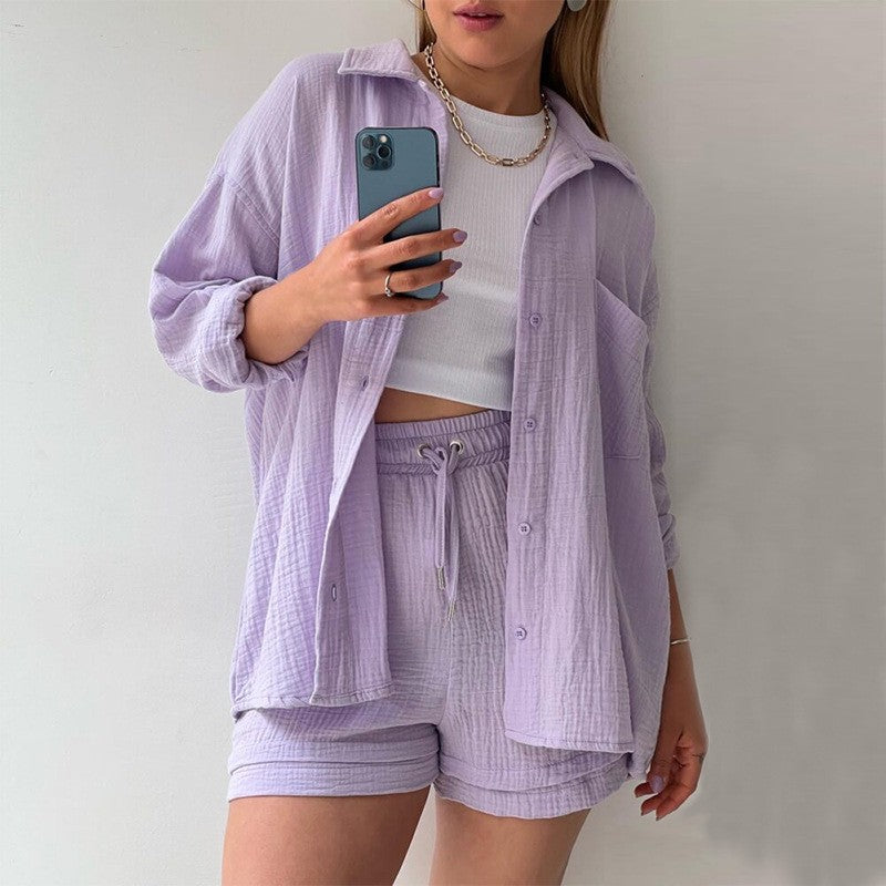 Donna in abbigliamento casual estivo, indossa camicia e shorts lilla, top bianco. Scatta selfie con smartphone. Moda femminile, stile estivo.