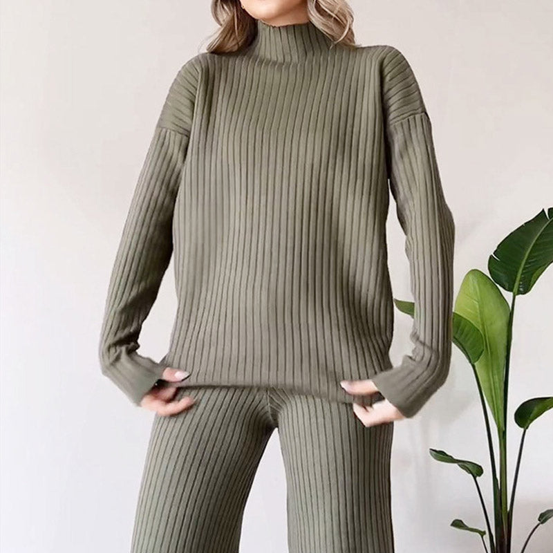 Donna con maglione e pantaloni a coste verdi, stile casual chic. Outfit autunnale elegante, moda femminile moderna. Pianta verde sullo sfondo.