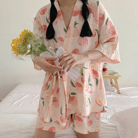 Donna in pigiama estivo con stampa di pesche, tiene un mazzo di girasoli. Abbigliamento da notte femminile, moda comoda, stile casual.