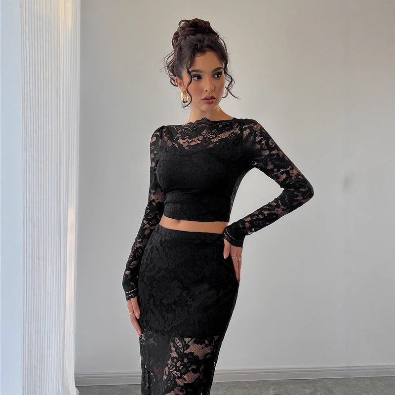 Donna in abito nero di pizzo, elegante e moderno, posa in una stanza minimalista. Moda femminile, abbigliamento da sera, stile sofisticato.