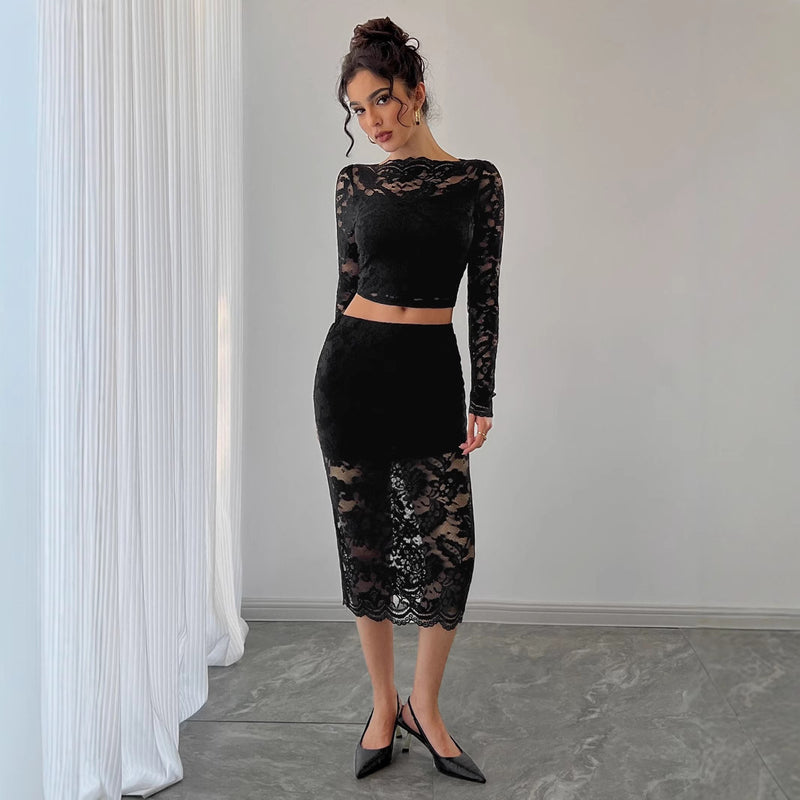 Donna in abito nero di pizzo trasparente, maniche lunghe, posa elegante. Moda femminile, abbigliamento da sera, stile sofisticato.