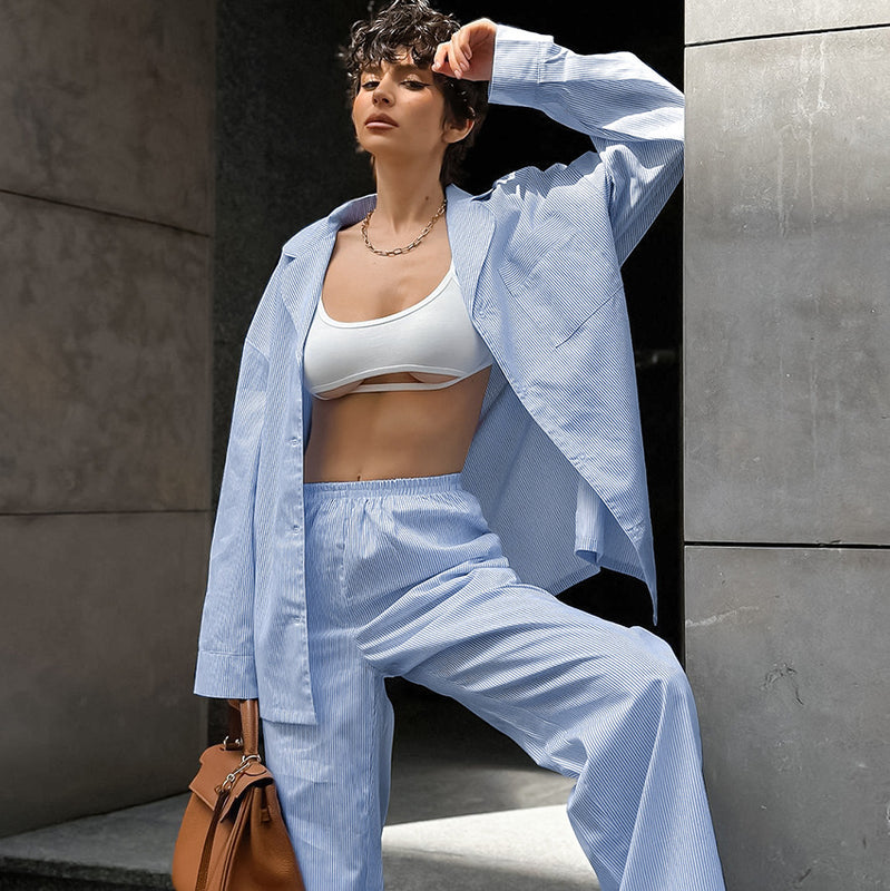 Donna con completo azzurro a righe, top bianco e borsa marrone. Moda estiva, stile casual chic, abbigliamento femminile trendy.