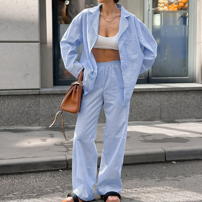 Donna in abbigliamento casual: camicia e pantaloni azzurri, top bianco, borsa marrone. Moda urbana, street style, tendenze abbigliamento femminile.