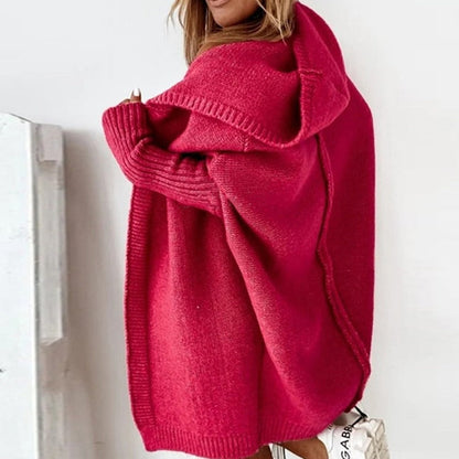 Donna con maglione oversize rosa acceso, cappuccio e dettagli a coste. Moda autunnale, abbigliamento casual, stile confortevole e trendy.