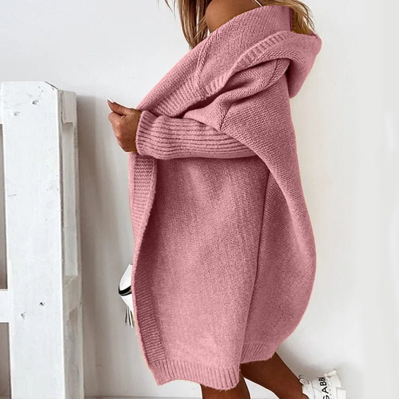 Donna con cardigan rosa oversize in maglia, stile casual autunnale, sfondo bianco. Moda femminile, abbigliamento caldo e accogliente.