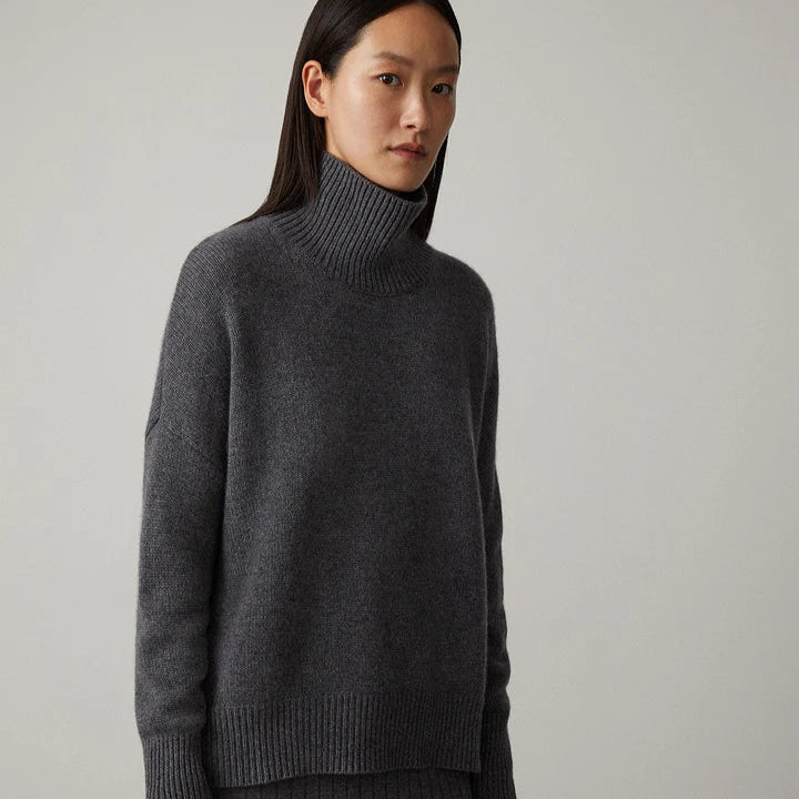 Maglione dolcevita grigio scuro in cashmere, indossato da una donna. Moda autunnale, abbigliamento caldo ed elegante, stile minimalista.