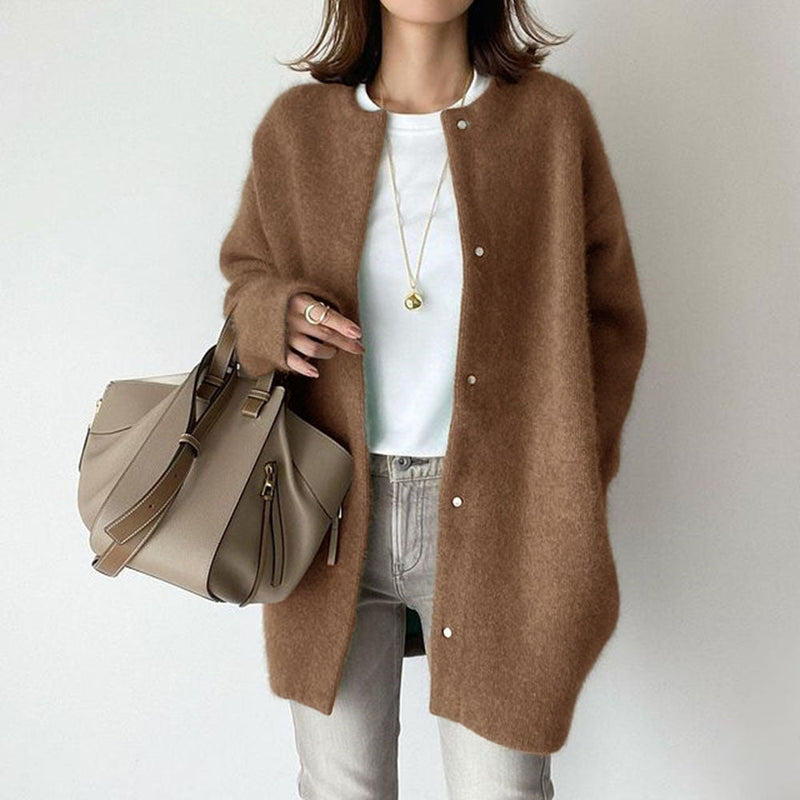 Donna con cardigan marrone, borsa beige e jeans chiari. Moda autunnale casual, stile elegante, accessori minimal. Look moderno e chic.