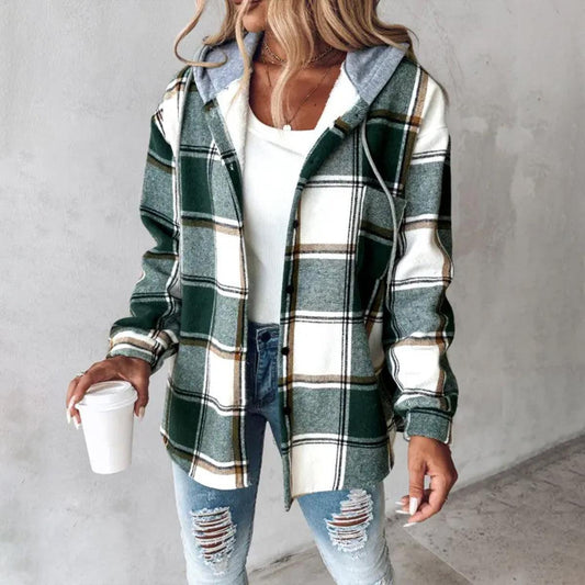 Donna con camicia a quadri verde e bianca, jeans strappati e maglietta bianca, tiene una tazza di caffè. Moda casual autunnale.