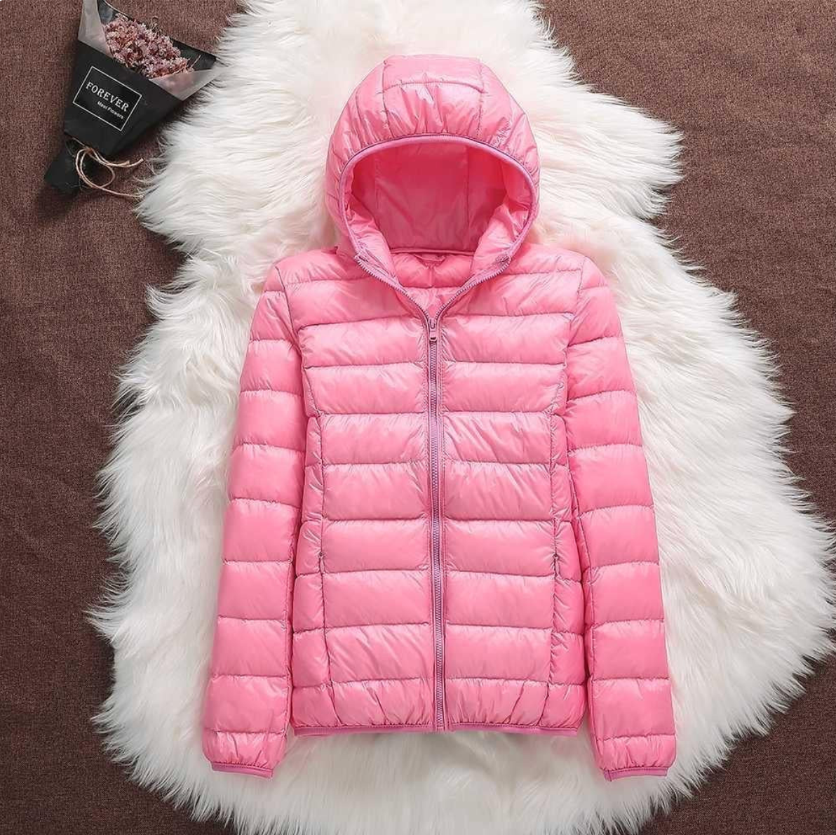 Giacca piumino rosa con cappuccio su sfondo di pelliccia bianca, moda invernale, abbigliamento caldo e leggero, stile casual per donna.