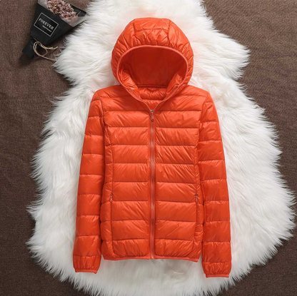 Giacca piumino arancione con cappuccio su sfondo di pelliccia bianca, moda invernale, abbigliamento caldo e leggero, stile casual.