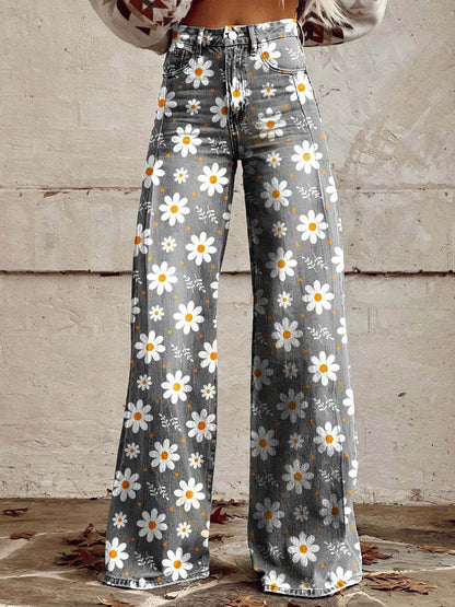 Jeans a zampa d'elefante grigi con stampa floreale di margherite bianche e gialle, indossati da una persona. Moda casual, stile vintage.