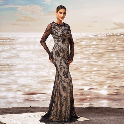 Donna in abito da sera lungo in pizzo nero, elegante e sofisticato, su spiaggia al tramonto. Moda femminile, abbigliamento di lusso, stile glamour.