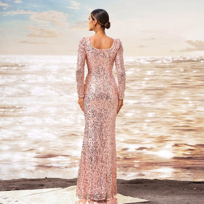 Donna in abito lungo rosa scintillante su spiaggia al tramonto, mare luccicante sullo sfondo. Eleganza, moda, abito da sera, stile glamour.