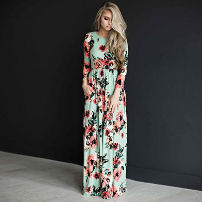 Abito lungo floreale verde menta con maniche lunghe, indossato da una donna bionda. Moda elegante, abbigliamento femminile, tendenza 2023.