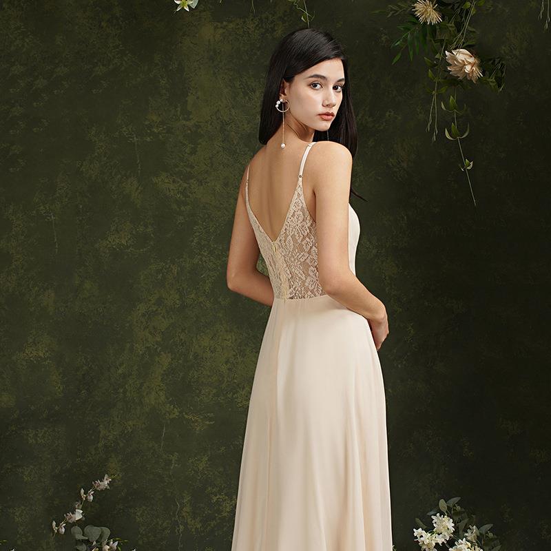 Donna in abito da sera elegante color crema con schiena in pizzo, sfondo verde con fiori. Moda femminile, abbigliamento formale, stile sofisticato.