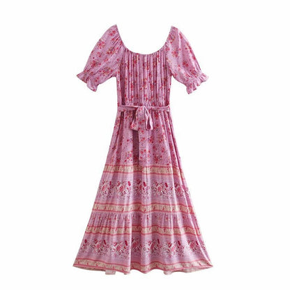 Abito lungo boho chic rosa con stampa floreale, maniche corte a sbuffo e cintura in vita. Perfetto per look estivi e casual eleganti.