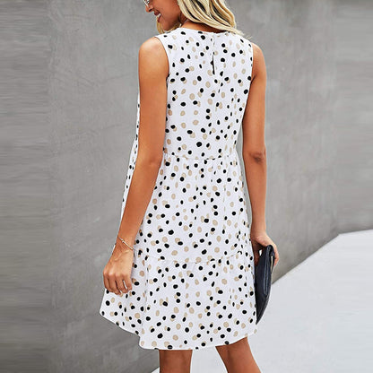 Abito estivo a pois bianchi e neri, senza maniche, indossato da una donna bionda. Moda casual elegante, perfetto per giornate calde.