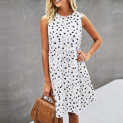 Abito estivo a pois bianchi e neri, senza maniche, indossato da una donna con borsa marrone. Moda casual femminile, look estivo elegante.