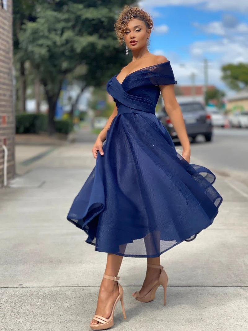 Donna con abito blu elegante, scollo a cuore, lunghezza media, su strada cittadina. Moda femminile, abbigliamento da sera, stile sofisticato.