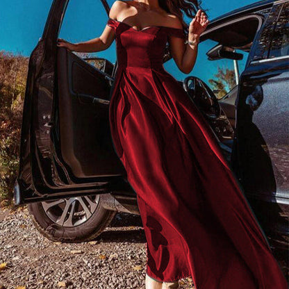 Donna in abito da sera rosso elegante, scende da un'auto nera. Moda glamour, abbigliamento formale, stile sofisticato.
