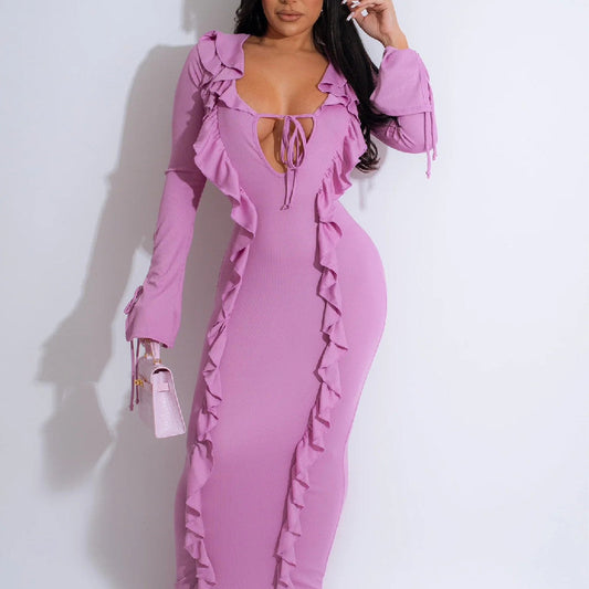 Donna in abito lungo rosa con volant, scollo profondo e maniche lunghe. Moda elegante, abbigliamento femminile, stile sofisticato.