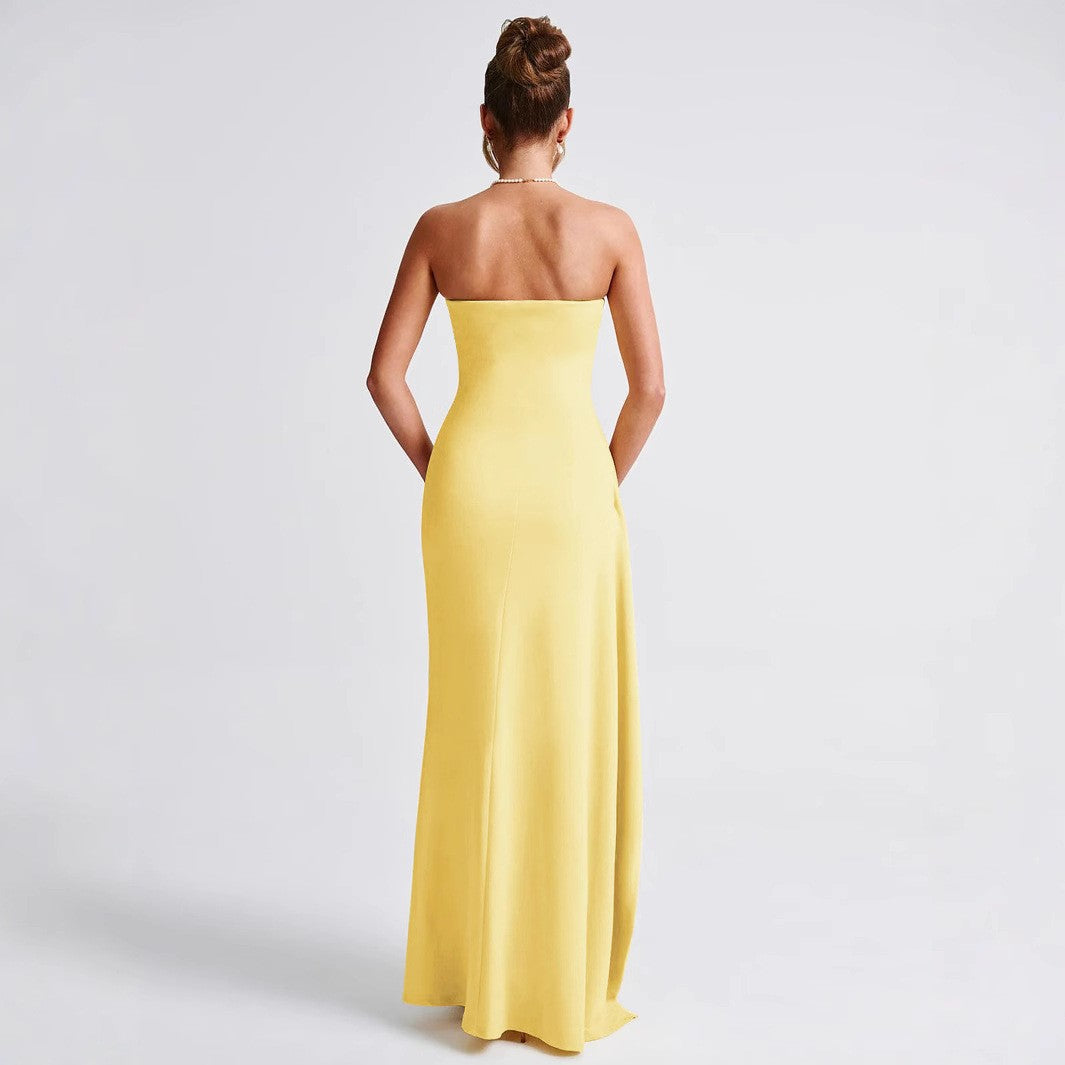Donna in abito lungo giallo senza spalline, vista posteriore. Moda elegante, abbigliamento da sera, tendenza abiti estivi 2023.