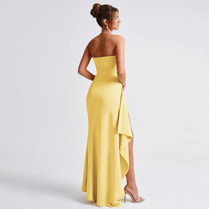 Donna in abito lungo giallo elegante, senza spalline, con spacco laterale, su sfondo bianco. Moda femminile, abbigliamento da sera, stile sofisticato.