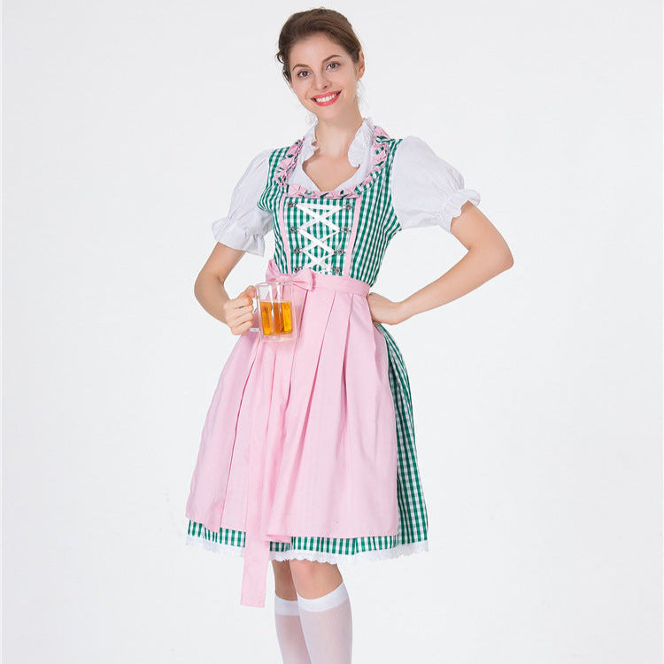 Donna in costume tradizionale bavarese con abito a quadri verdi e grembiule rosa, tiene un boccale di birra. Oktoberfest, abbigliamento tradizionale.
