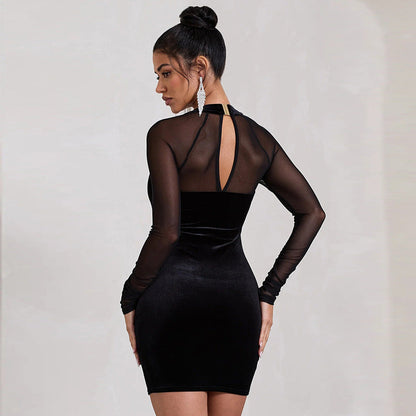 Abito nero elegante con maniche trasparenti e scollatura posteriore, indossato da una donna con capelli raccolti e orecchini pendenti.