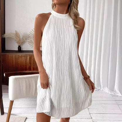 Donna con abito bianco plissettato senza maniche, elegante e moderno, in un ambiente minimalista. Moda estiva, abbigliamento femminile chic.
