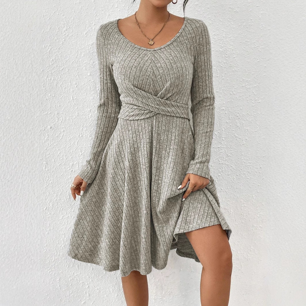 Abito grigio a coste con maniche lunghe e scollo a V, design incrociato in vita, tessuto morbido e fluente, perfetto per look casual ed eleganti.